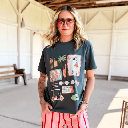 Woman wearing a graphic t-shirt with colorful designs in an indoor setting.
